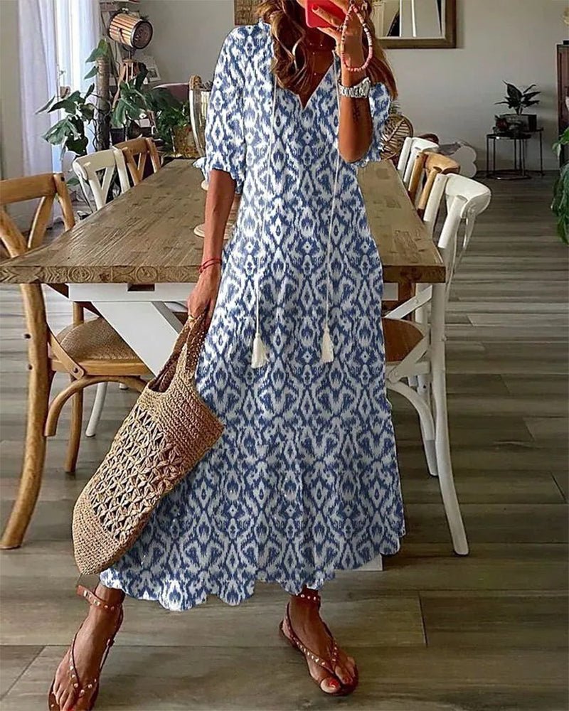 A woman wearing the Margaret boho midi dress with tassel ties at the neckline and a ruffled skirt.