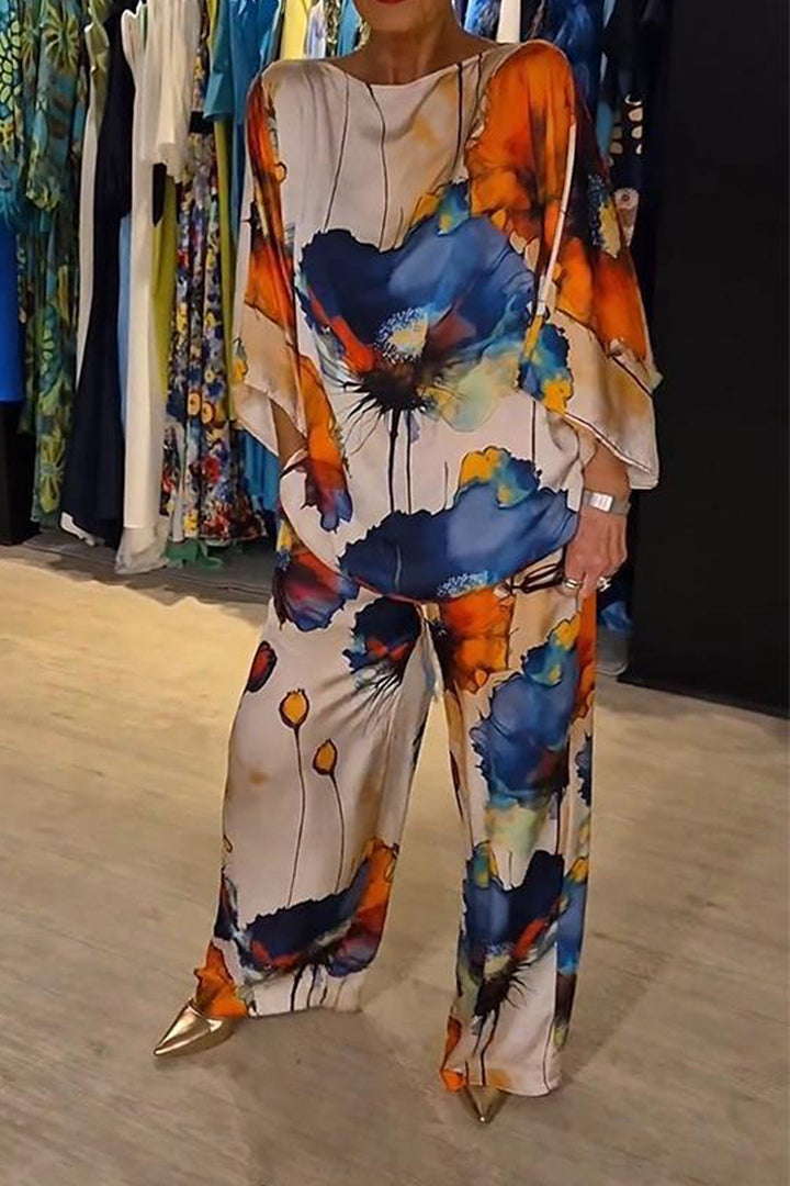 A woman wearing a bold floral print two-piece set with a loose flowing fit, vibrant and elegant.