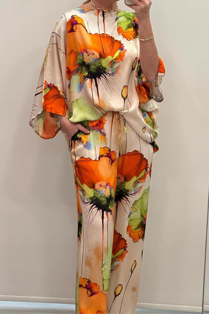 A woman wearing a bold floral print two-piece set with a loose flowing fit, vibrant and elegant.