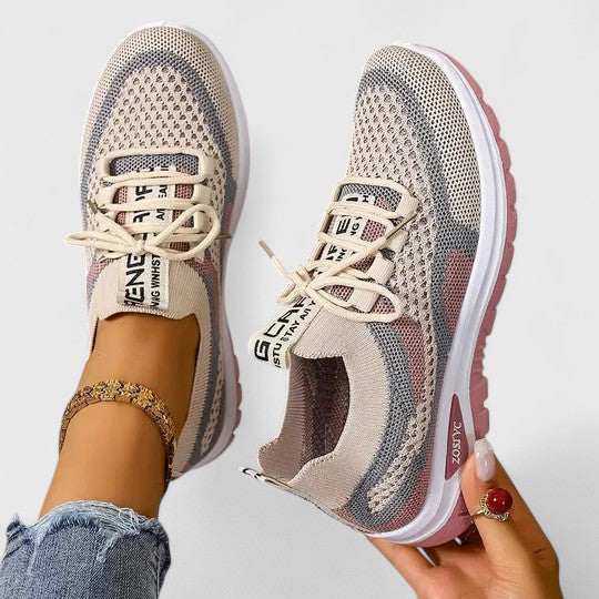 A woman lacing up light, breathable orthopaedic sneakers before a walk.