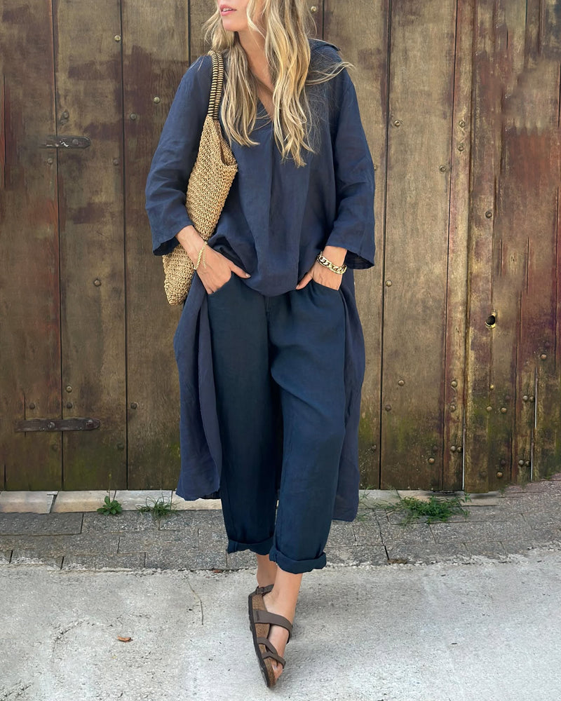 A woman wearing a blue asymmetric tunic with wide-leg pants