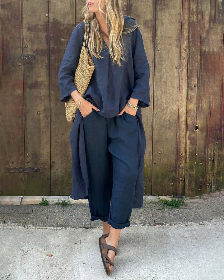 A woman wearing a blue asymmetric tunic with wide-leg pants