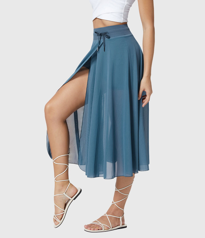 A woman in an elegant high-waisted flowing skirt, styled for a versatile day-to-evening look.