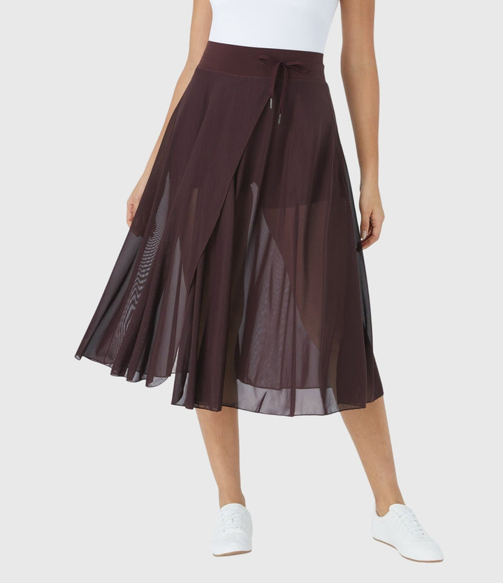 A woman in an elegant high-waisted flowing skirt, styled for a versatile day-to-evening look.