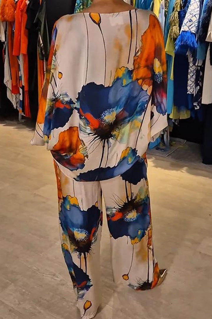 A woman wearing a bold floral print two-piece set with a loose flowing fit, vibrant and elegant.
