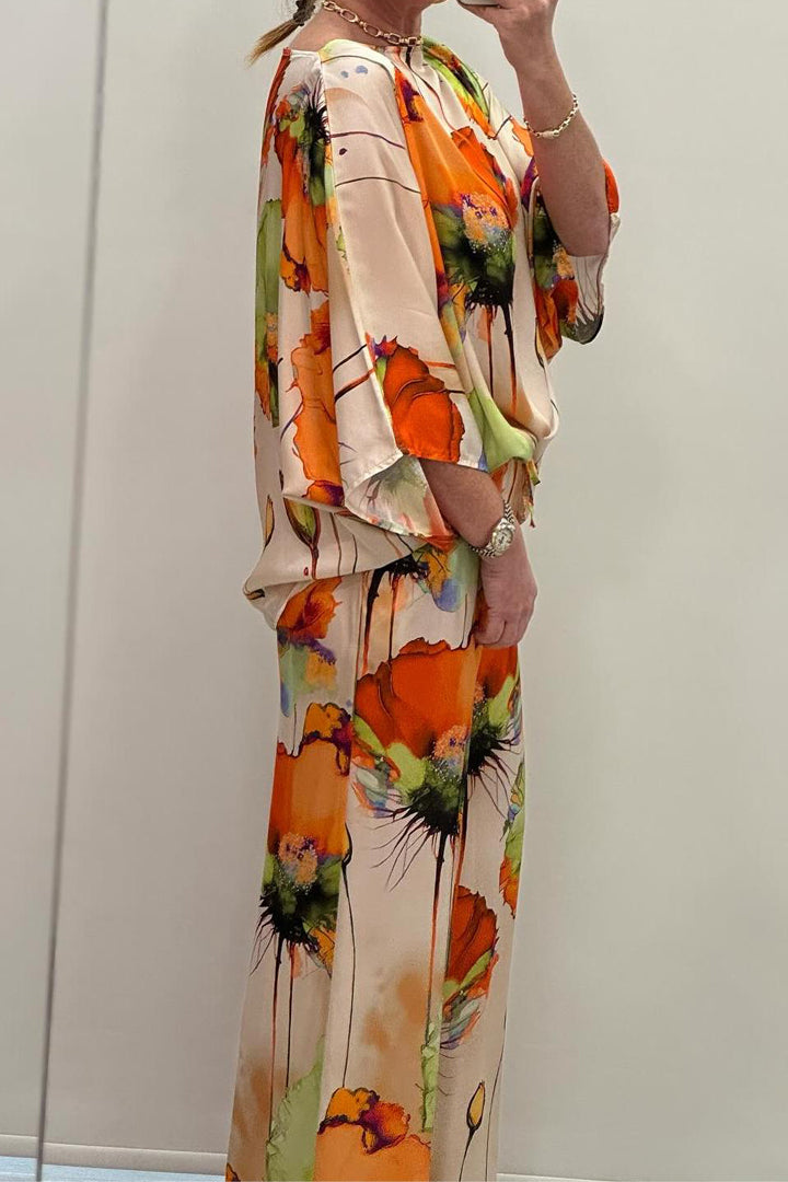 A woman wearing a bold floral print two-piece set with a loose flowing fit, vibrant and elegant.