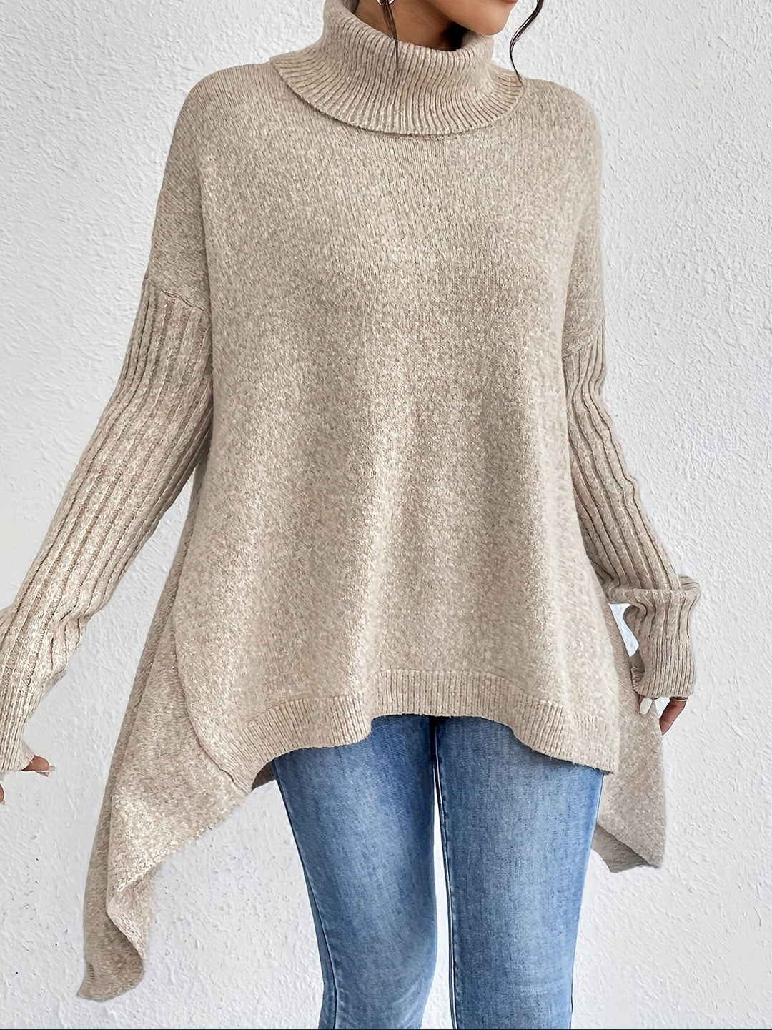 A woman wearing a stand-collar sweater with a chic asymmetric drape, warm and polished.