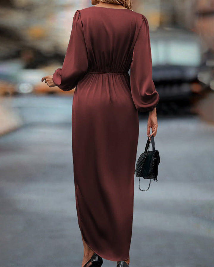 Woman in the Connie draped evening dress with long sleeves and a softly gleaming finish, ready for an elegant night out.