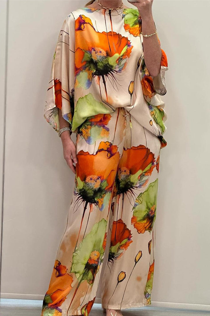 A woman wearing a bold floral print two-piece set with a loose flowing fit, vibrant and elegant.