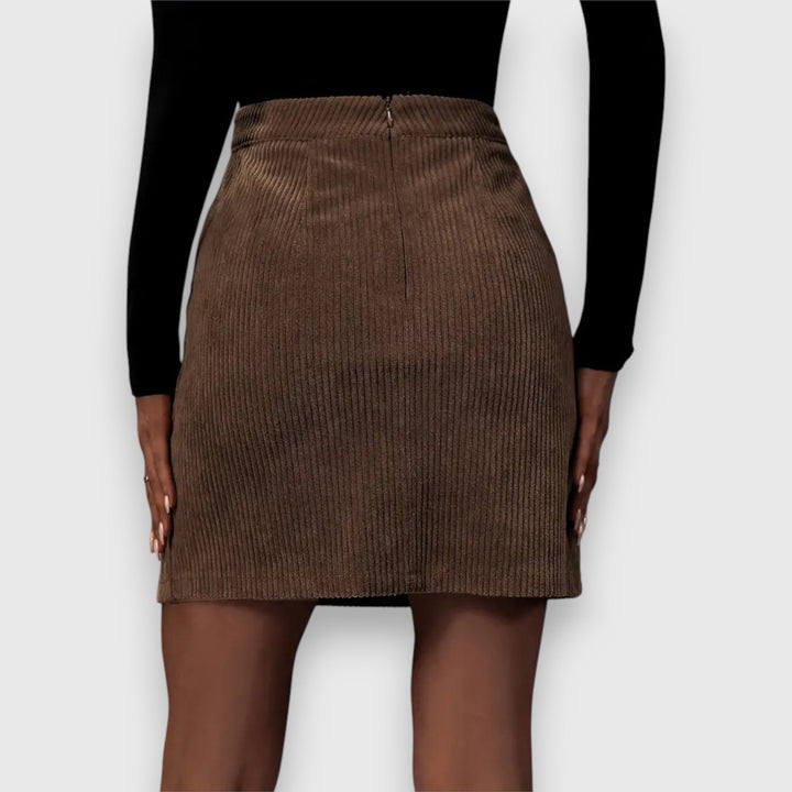 A woman in a textured ribbed skirt with a front slit, styled with a sweater for a relaxed fall look.