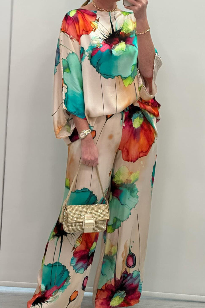 A woman wearing a bold floral print two-piece set with a loose flowing fit, vibrant and elegant.