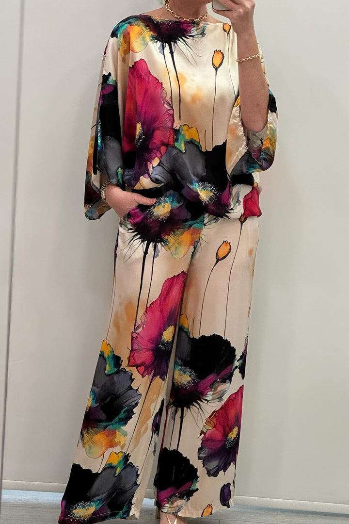 A woman wearing a bold floral print two-piece set with a loose flowing fit, vibrant and elegant.