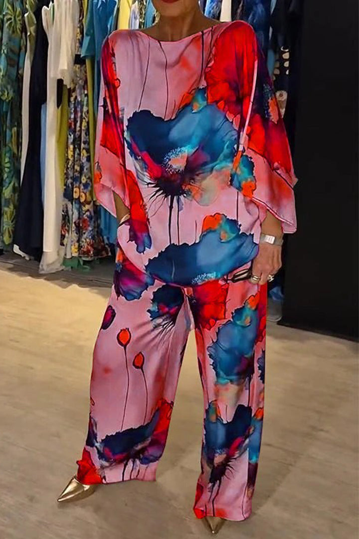 A woman wearing a bold floral print two-piece set with a loose flowing fit, vibrant and elegant.