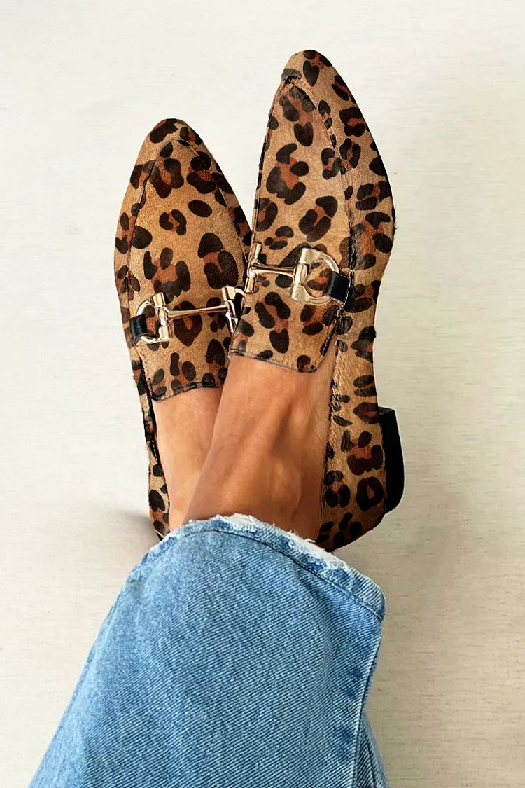 A woman wearing leopard print slip-on loafers, styled for an easy day in the city.