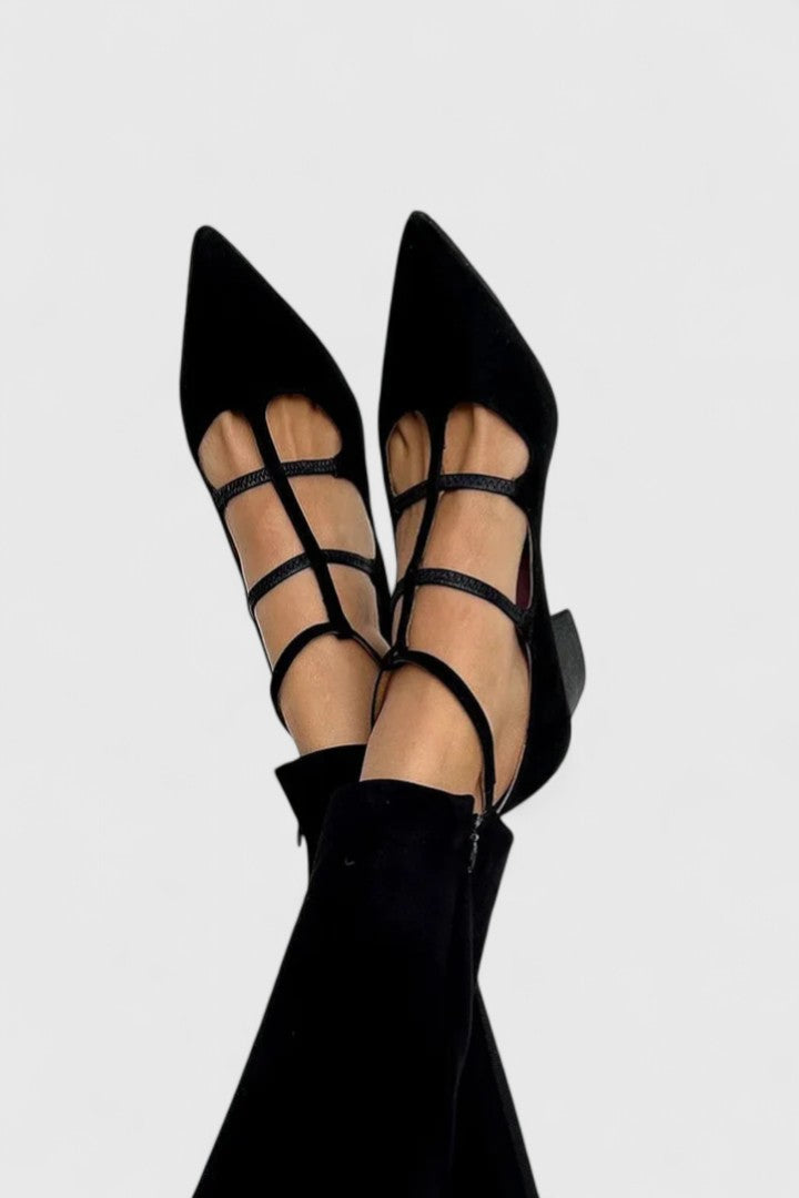 A woman in classic black heels walking confidently through the city on an everyday outing.