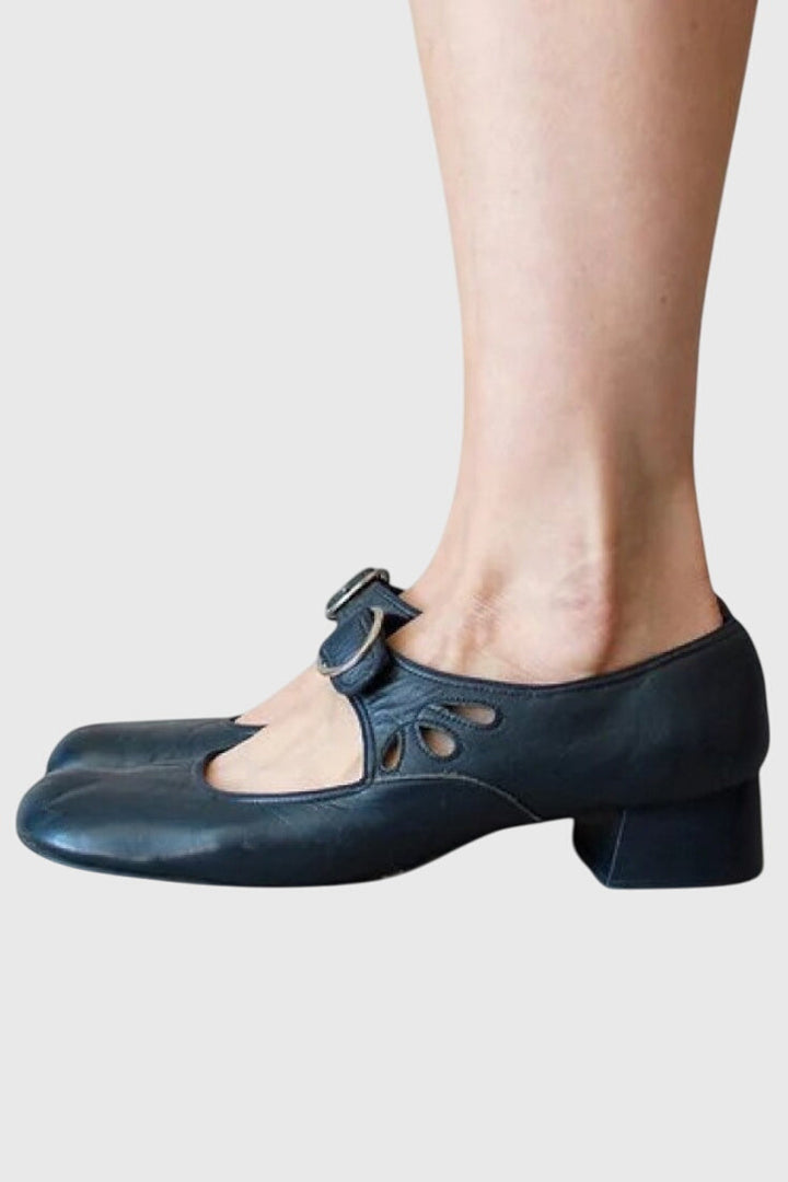 A woman wearing low heel Mary Janes with an adjustable strap, dressed for work.