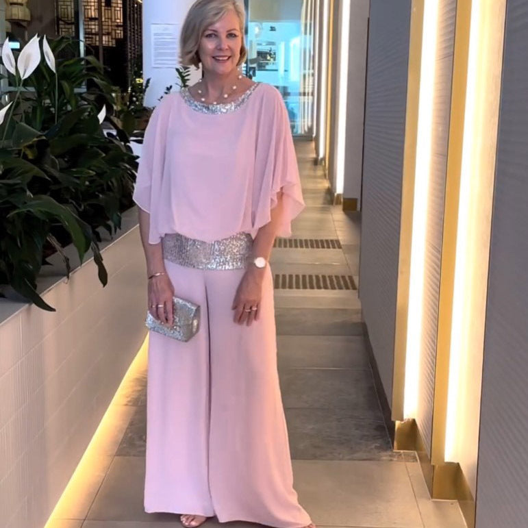 A woman wearing an embellished blouse-style top with softly flowing wide evening pants.
