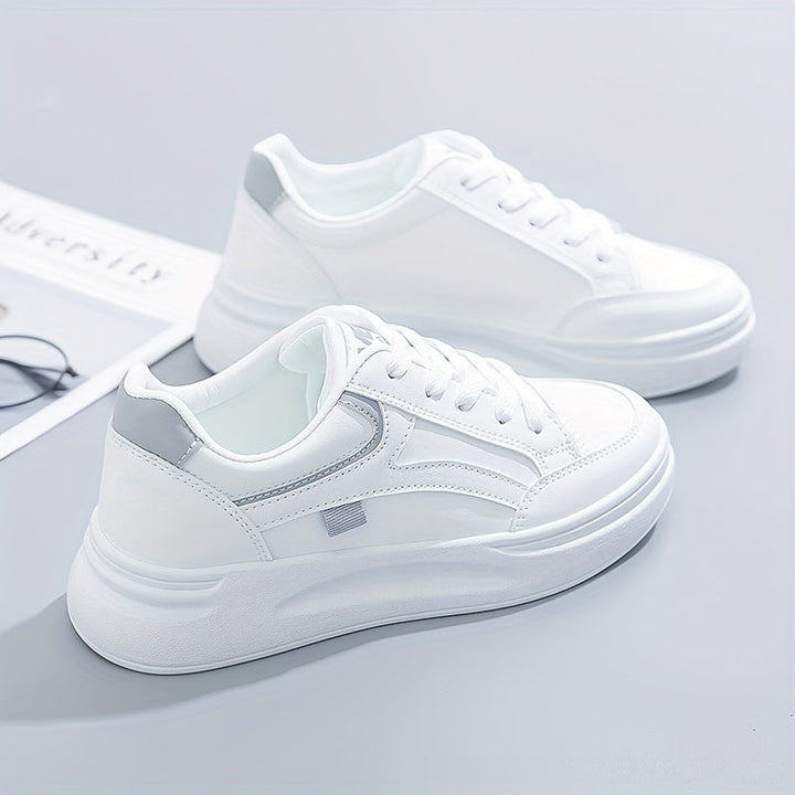 A woman in crisp white light comfort sneakers paired with jeans.