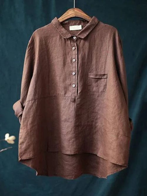 Woman wearing a plain flowing summer blouse in a warm solid colour, falling softly around her figure.