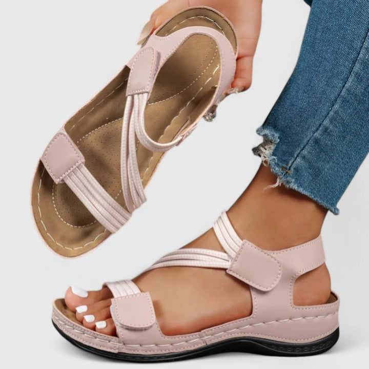 A woman wearing soft adjustable comfort sandals with a summer outfit, looking relaxed and content.