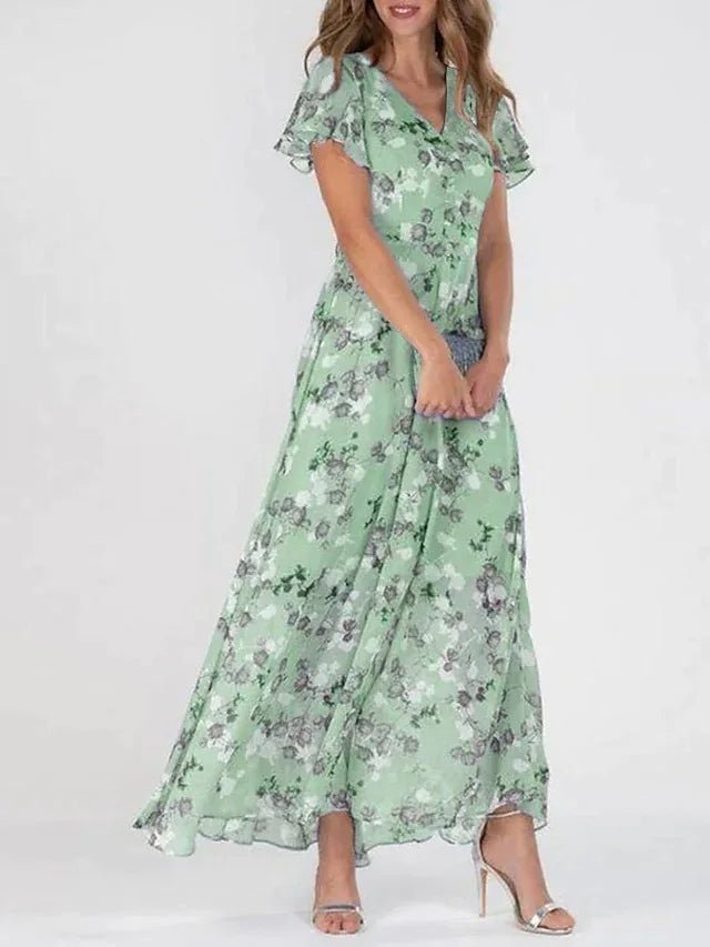 Woman wearing a long flowing wrap-effect maxi dress with a subtle floral print and floaty sleeves.