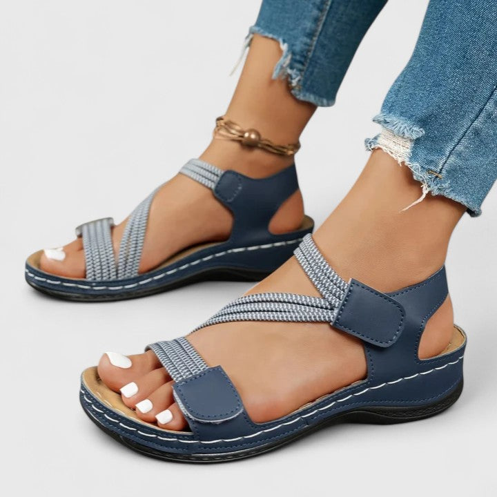 A woman wearing soft adjustable comfort sandals with a summer outfit, looking relaxed and content.