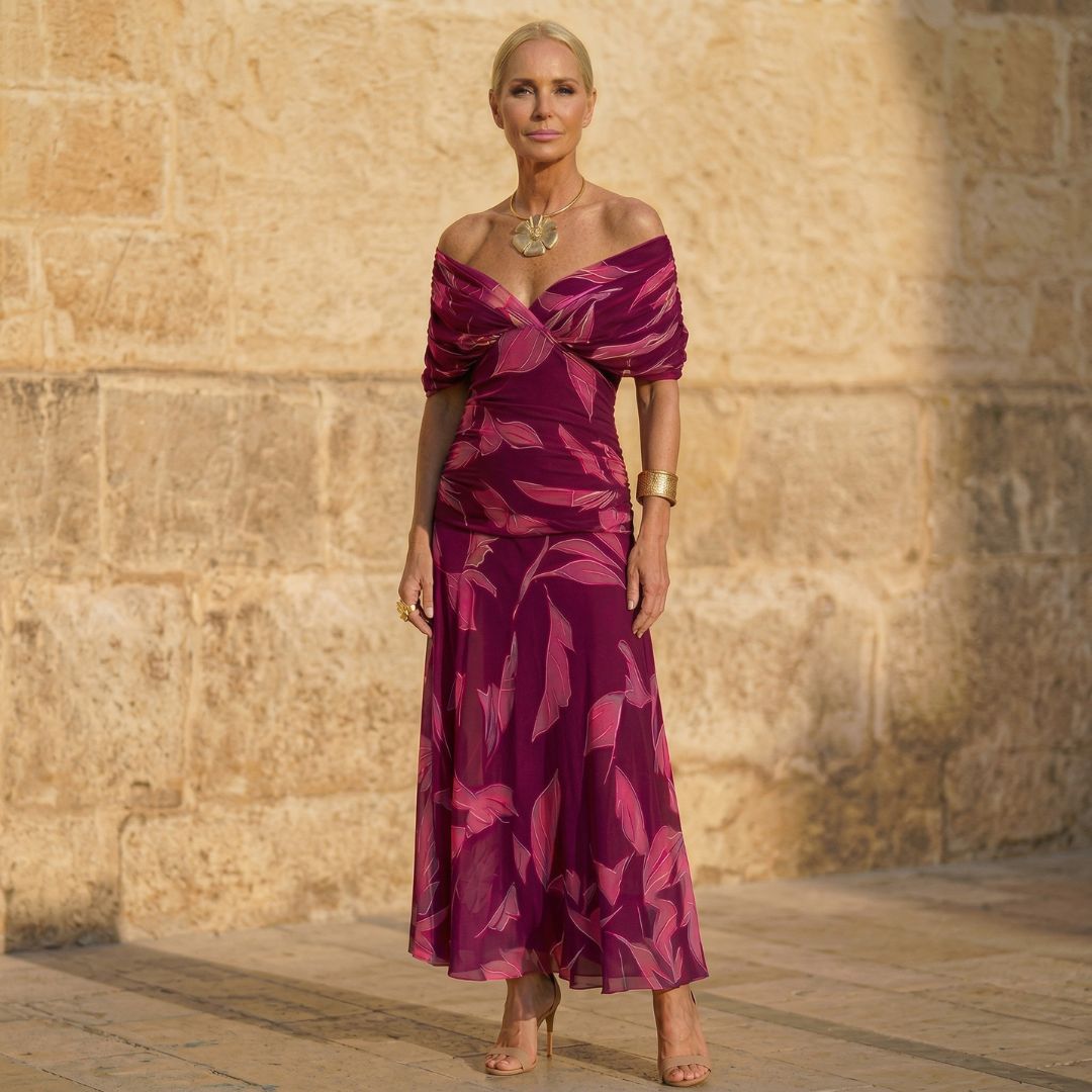 A woman wearing a flowing purple dress with a soft leaf print at an afternoon occasion.