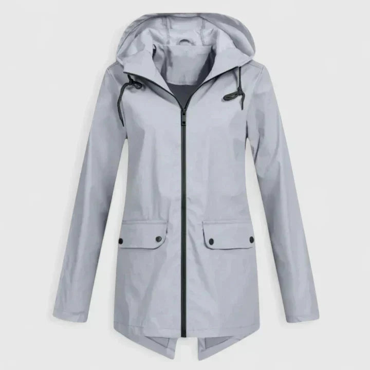A woman wearing a hooded rain jacket, walking outdoors in light rain