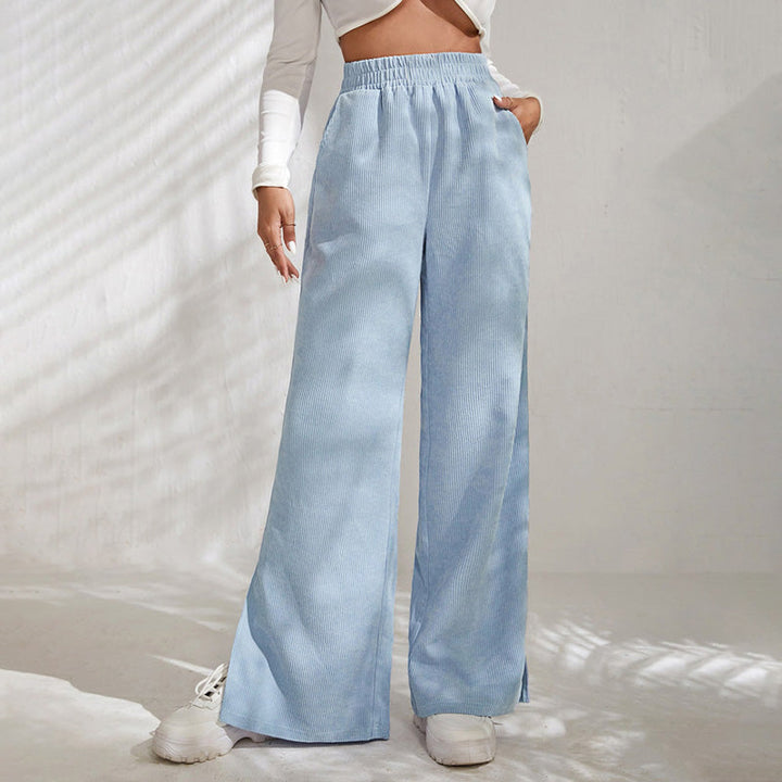 Woman wearing wide-leg ribbed joggers with a fitted top, relaxed at home.