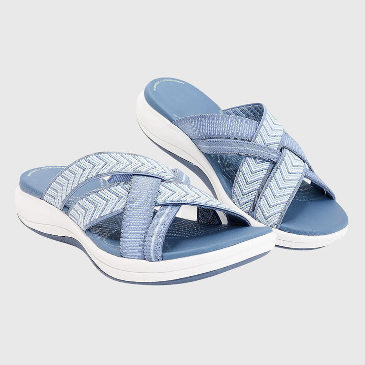 A woman in beige lightweight soft sandals walking easily on a sunny path, feet cushioned and supported.