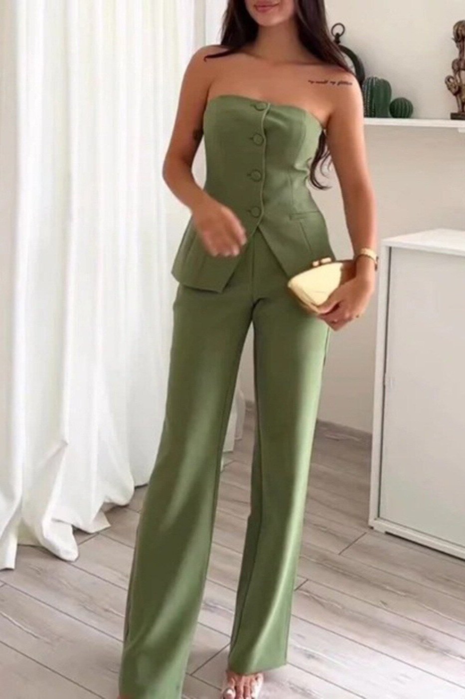 A woman wearing a tailored sleeveless button-detail top with matching wide-leg pants.