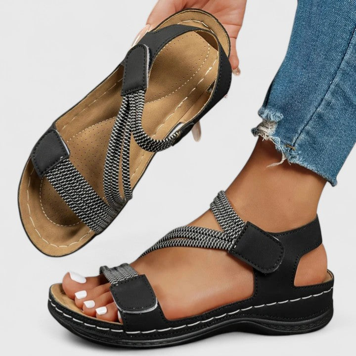 A woman wearing soft adjustable comfort sandals with a summer outfit, looking relaxed and content.