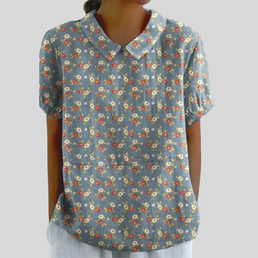 A woman wearing a versatile floral top with a refined collar, moving easily from day to evening.