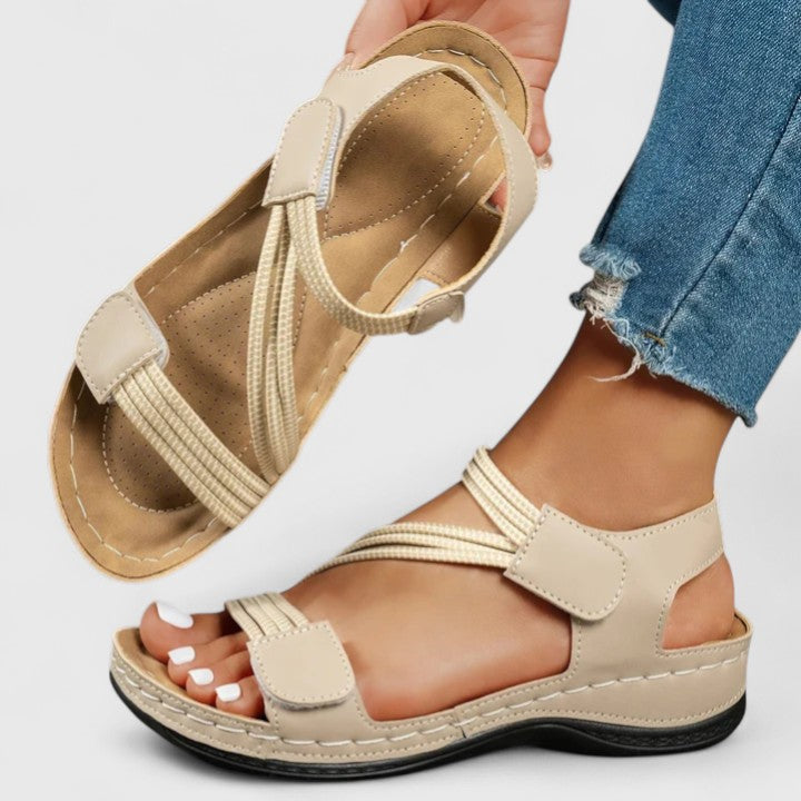 A woman wearing soft adjustable comfort sandals with a summer outfit, looking relaxed and content.