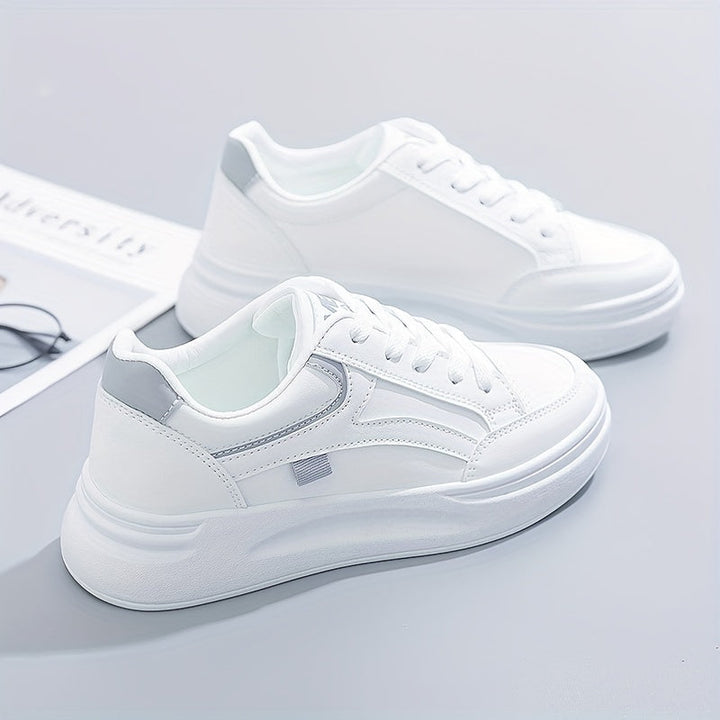 A woman in crisp white light comfort sneakers paired with jeans.