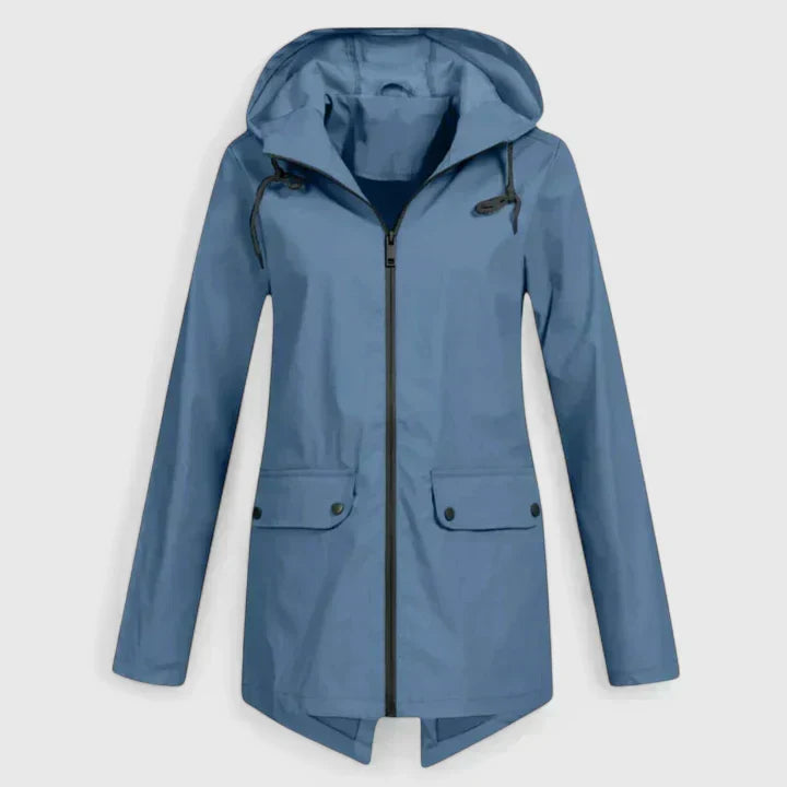 A woman wearing a hooded rain jacket, walking outdoors in light rain