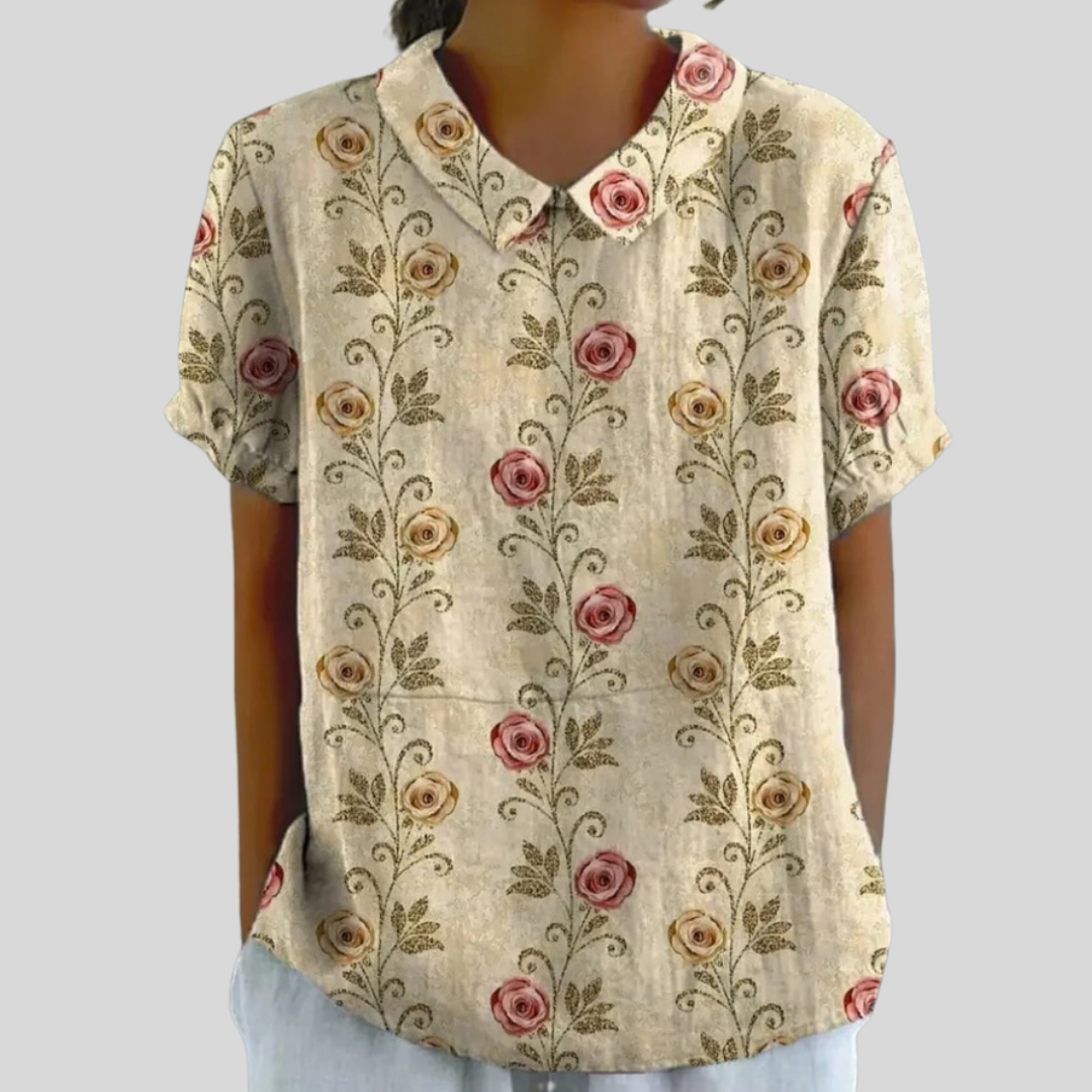 A woman wearing a floral top with an elegant polo collar, styled neatly with pants for an easy, put-together look.