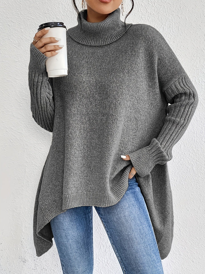 A woman wearing a stand-collar sweater with a chic asymmetric drape, warm and polished.