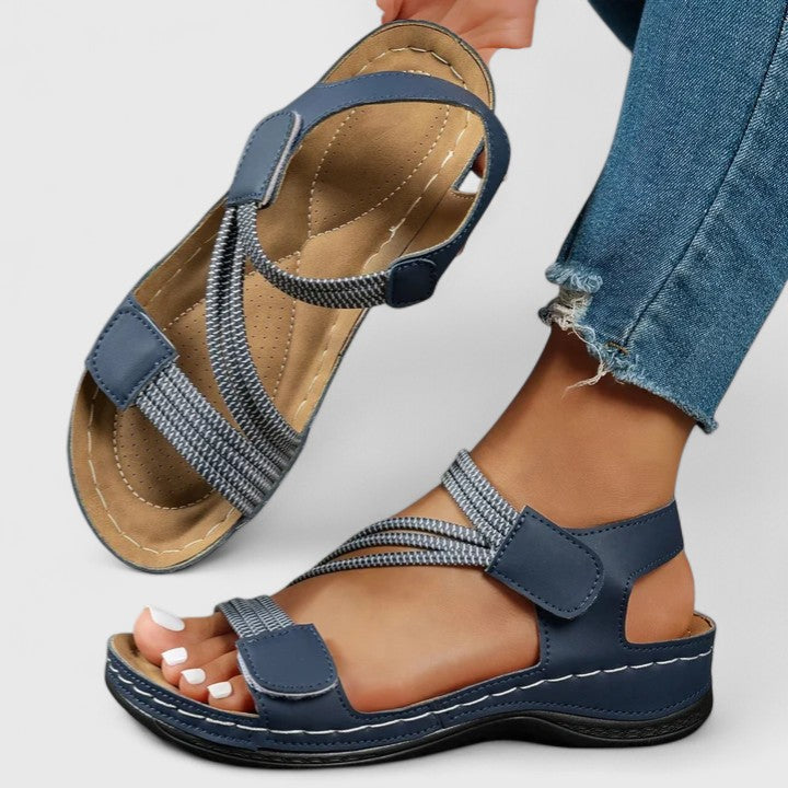 A woman wearing soft adjustable comfort sandals with a summer outfit, looking relaxed and content.
