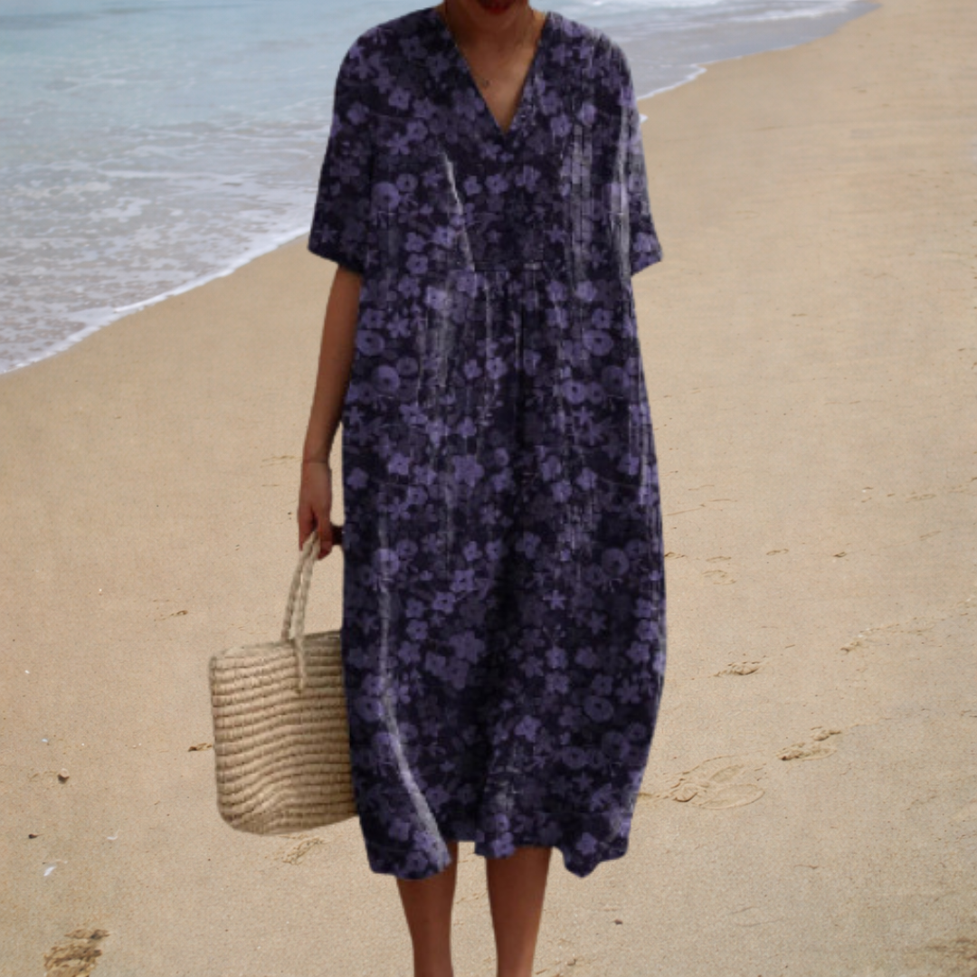 A woman wearing a comfortable loose patterned summer dress, relaxed and elegant in the warm sun.