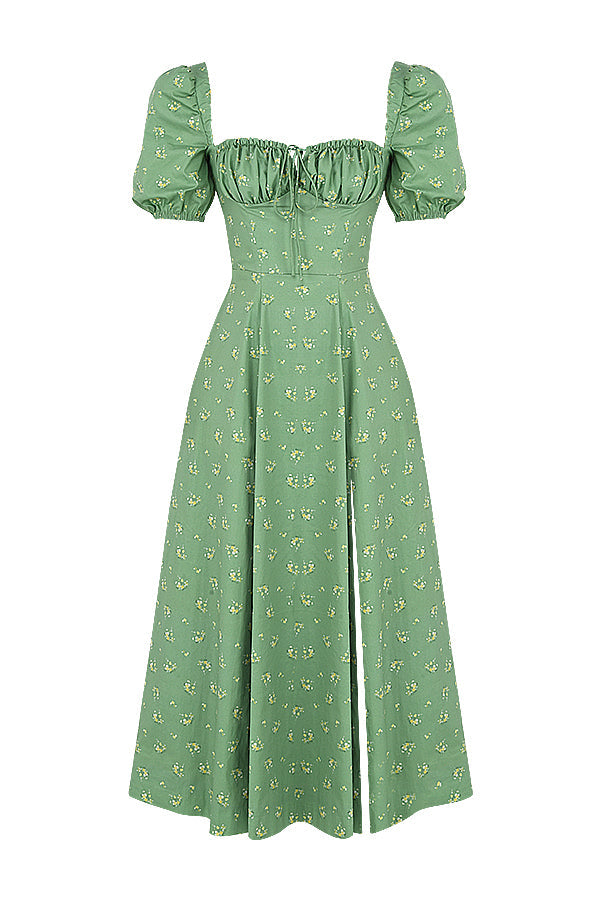 A woman wearing a floral midi dress with puff sleeves and a tie-front bodice, standing in the sunshine.