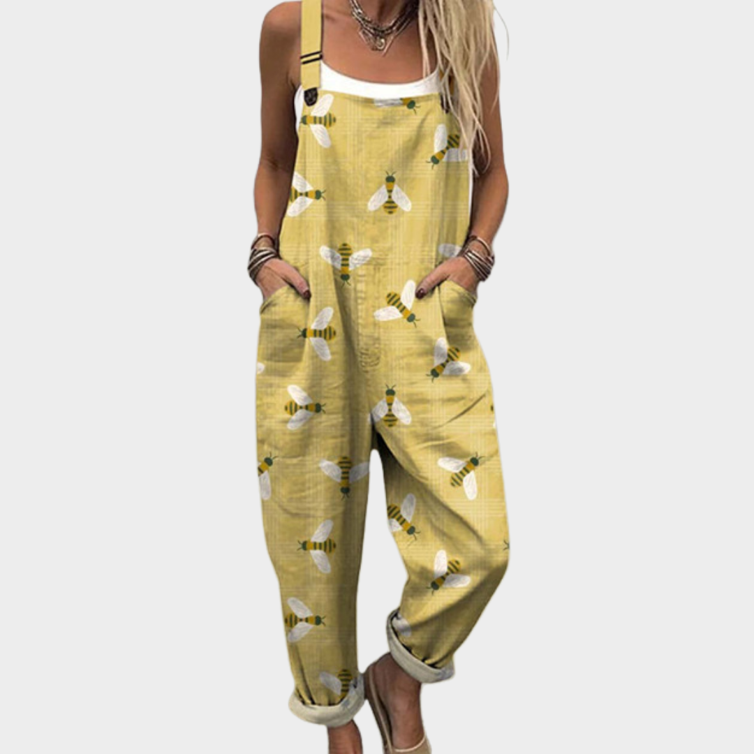 Woman wearing warm mustard overalls printed with delicate bees with white wings