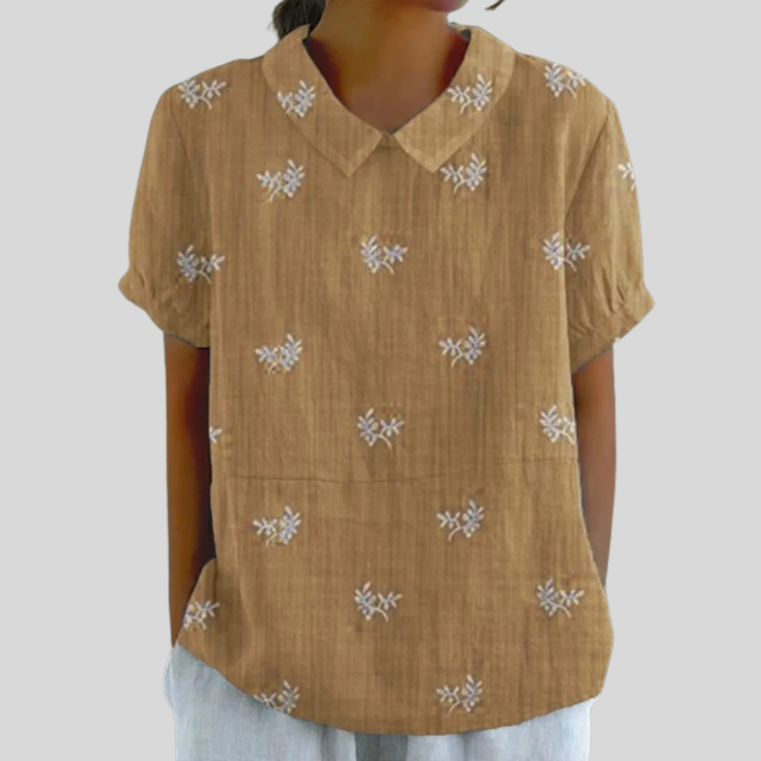 A woman wearing a floral top with a polo collar on a relaxed day out