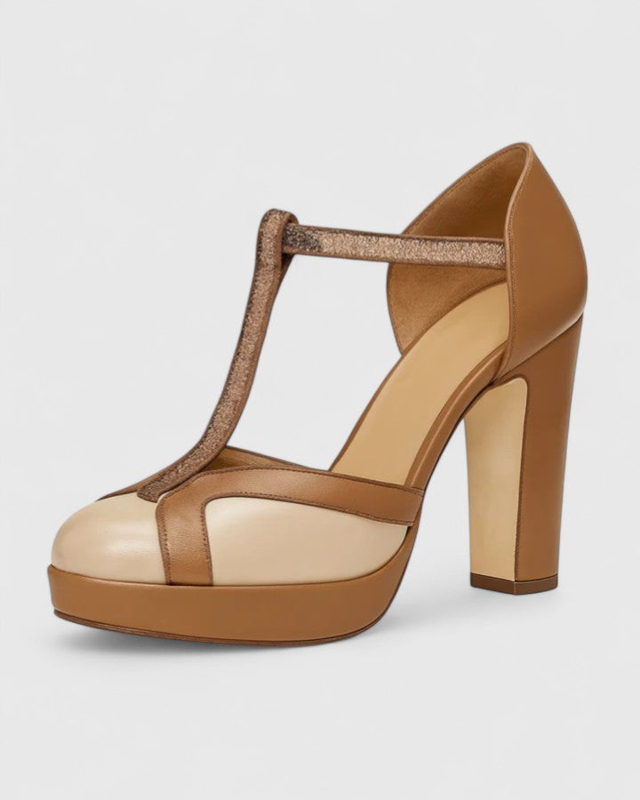 A woman wearing brown T-strap heels with a vintage round toe, stepping out confidently.
