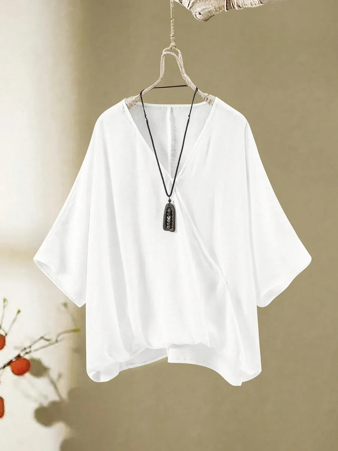 A woman wearing a flowing V-neck knot-detail top with matching flared pants.