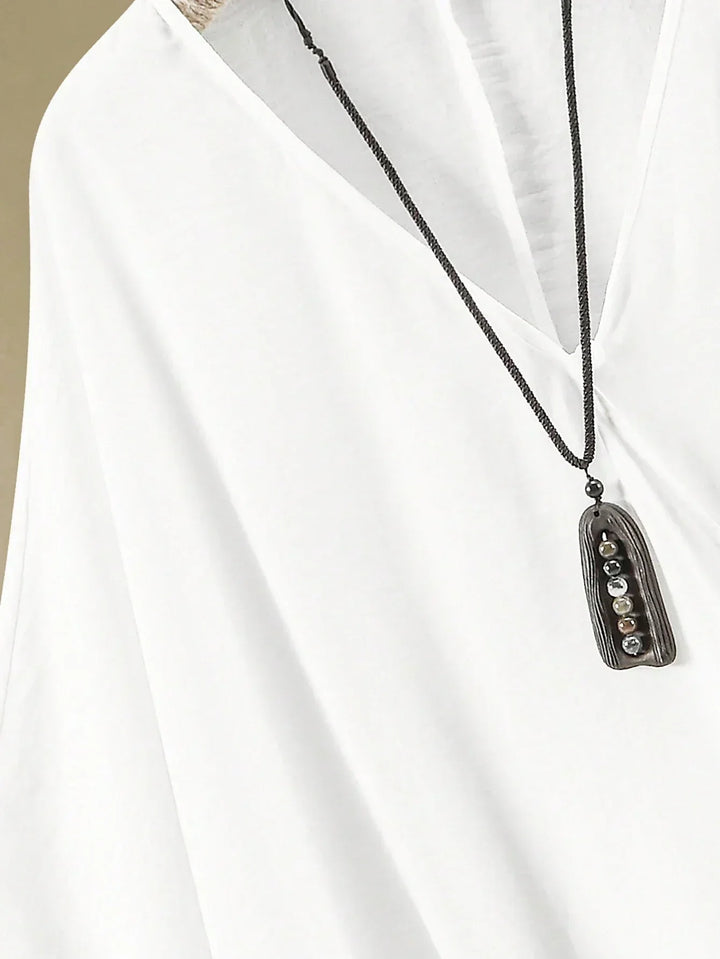 A woman wearing a flowing V-neck knot-detail top with matching flared pants.