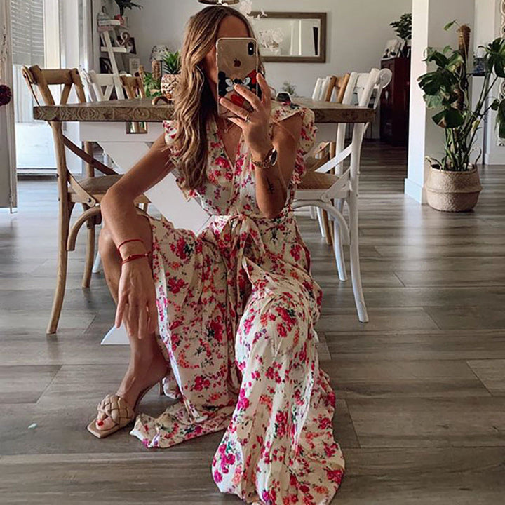 Woman in a flowing floral maxi dress with a tied waist at a summer garden gathering.