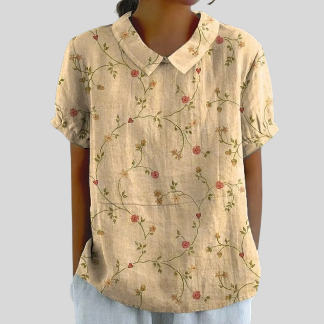 A woman wearing a classic floral top with a refined collar, ready for the day with easy confidence.