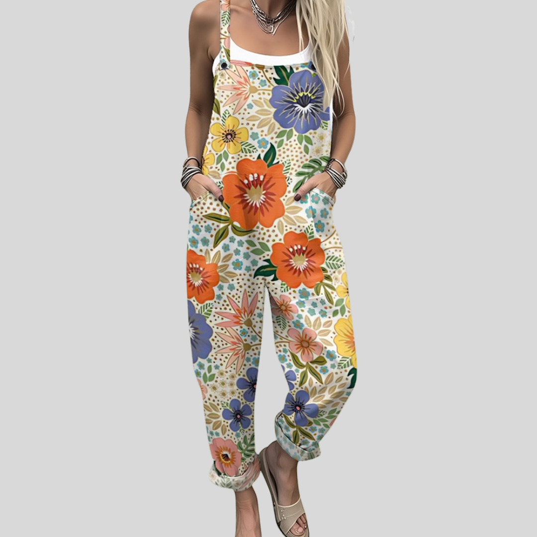 A woman wearing overalls in a lush multicolour floral print of orange, blue and green blooms.
