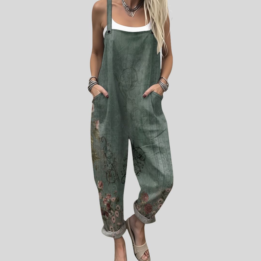 A woman wearing warm olive-green overalls with a floral and paisley border along the lower leg.
